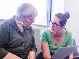 Two women discussing paperwork