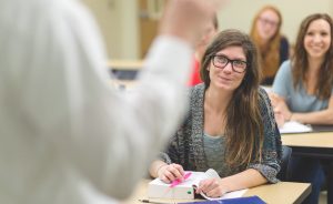 Woman taking notes listening to presenter