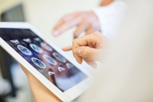 Two individuals observing tablet screen