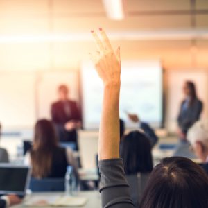 Woman raising hand in classroom