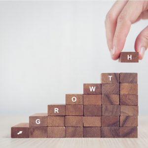 Hand arranging wood block stacking as step stair with growth written